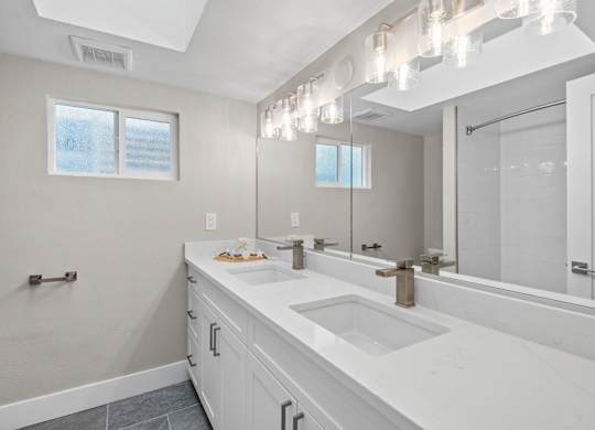 A bathroom with a large mirror and a window.