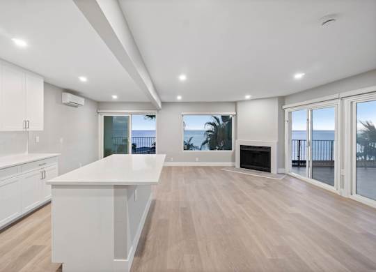 A spacious kitchen with white cabinets and a large island.at Ocean Edge @ Laguna Beach, Laguna Beach California