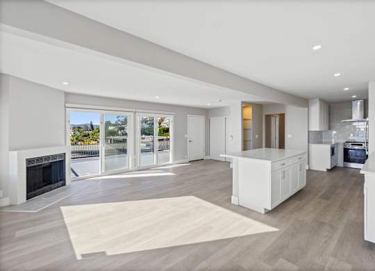 A modern kitchen with a fireplace and a view of the outdoors.at Ocean Edge @ Laguna Beach, Laguna Beach