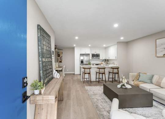 A modern living room with a bar area and a kitchen in the background at Tamarack Sands Apartment Homes, Carlsbad, CA, 92008