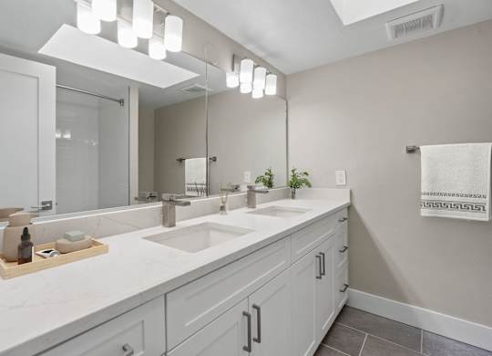 A bathroom with a white counter top and a large mirror.at Ocean Edge @ Laguna Beach, California, 92651