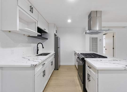 A white kitchen with a black stove top oven. at Torrance Gateway Apartments, Torrance, 90501