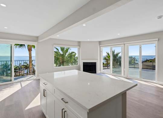 A modern kitchen with a large island and a view of the oceanat Ocean Edge @ Laguna Beach, Laguna Beach, CA.