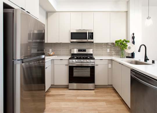 A modern kitchen with stainless steel appliances and white cabinets. at The Reserve La Mirada, La Mirada