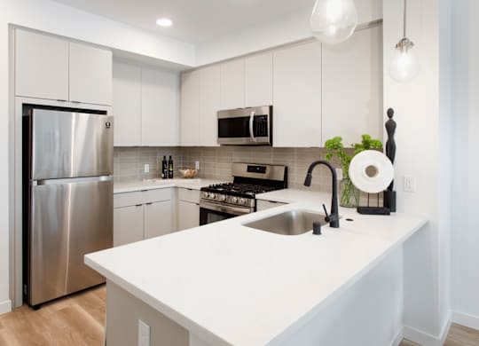 A modern kitchen with a stainless steel refrigerator and a white countertop. at The Reserve La Mirada, La Mirada, California