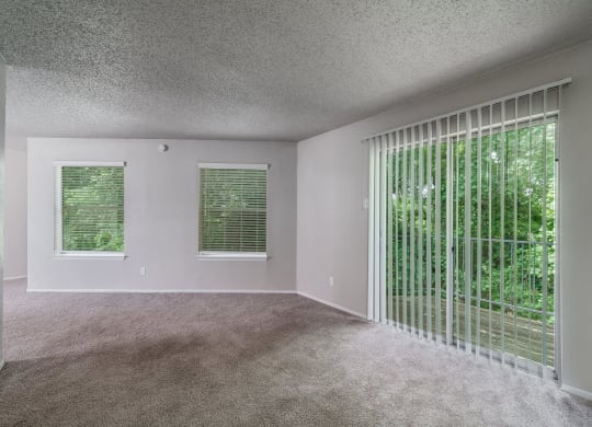 an empty living room with blinds and a window  at Shadow Ridge, Texas