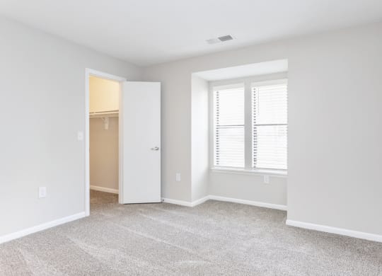 an empty room with a window and a closet