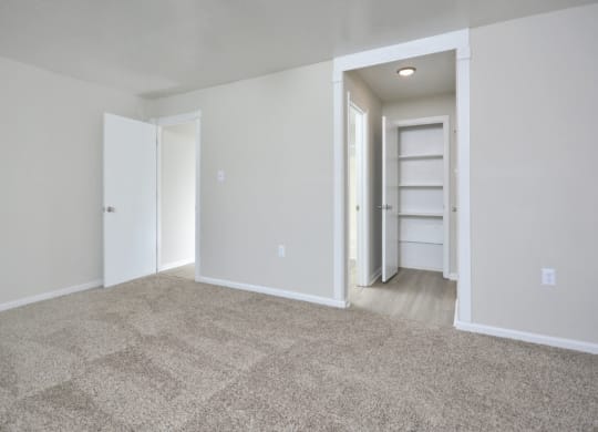 an empty living room with white walls and carpet