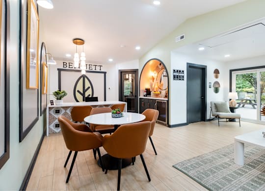 A modern dining room with a white table and chairs.