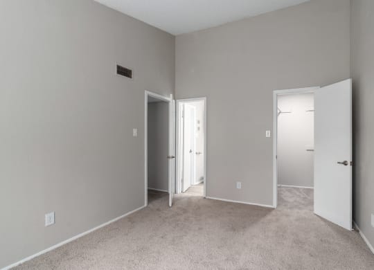 a bedroom with a carpeted floor and a door to a closet