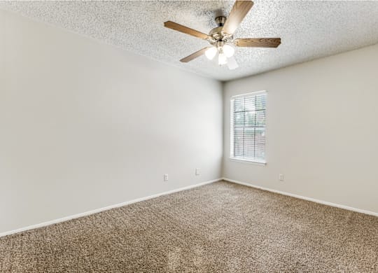 A room with a ceiling fan and a window.