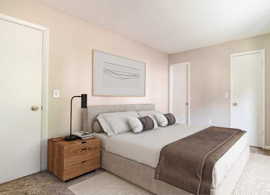 A bedroom with a bed, nightstand, and lamp.
