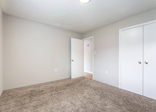 A room with a carpeted floor and white walls.