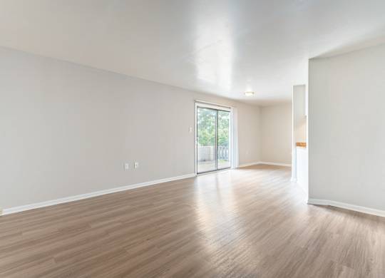 A room with wooden floors and a sliding glass door.