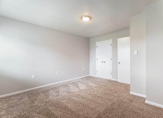 A room with carpeted floor and white walls.