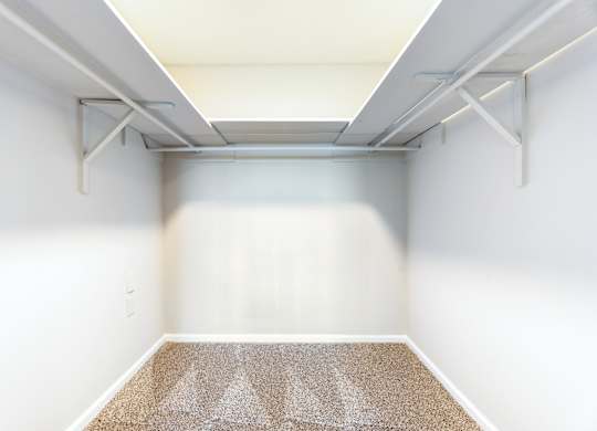 A room with a carpet and a white wall.
