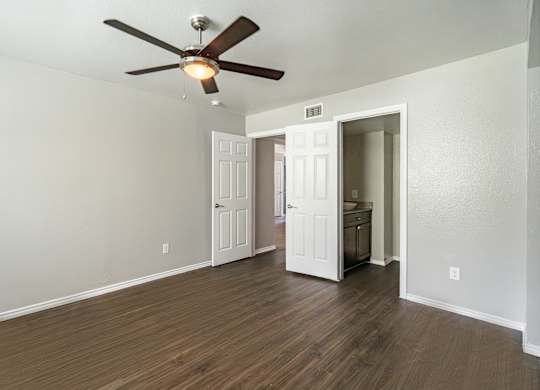 Empty bedroom with ceiling fan and hardwood flooring at Lumina Apartments, Dallas, Texas