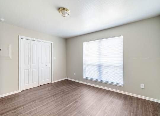 Spacious bedroom with large window and laminate floors at Lumina Apartments, Dallas, 75240