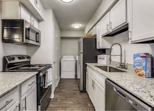 A kitchen with a black refrigerator and a white oven.