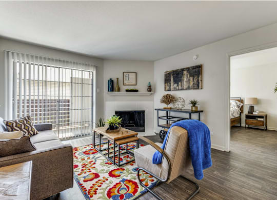 A living room with a fireplace, a chair, and a rug.