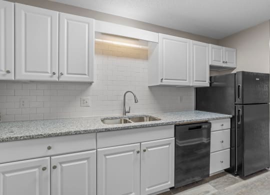 kitchen with quartz countertops and white backsplash at Bennett, North Carolina