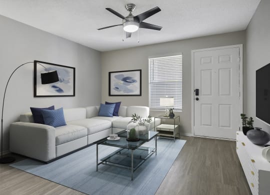 a living room with a white couch and a ceiling fan