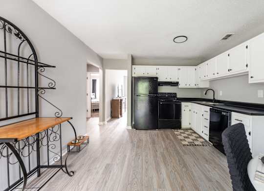 A kitchen with white cabinets and a black oven.at Lauradale, North Carolina