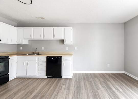 A kitchen with black appliances and white cabinets.at Lauradale, North Carolina