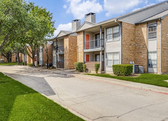 A row of apartment buildings with a tree in front of them.