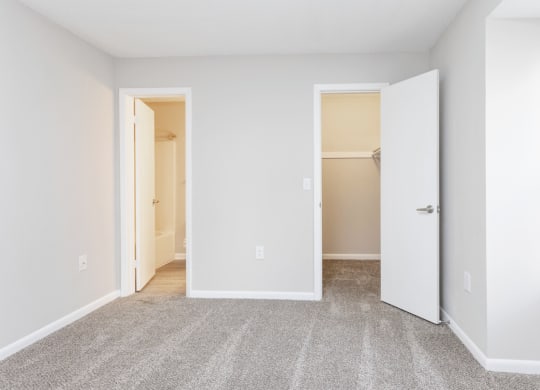 an empty room with white walls and a door to a closet