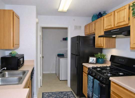 A kitchen with a black stove top oven and a black microwave.