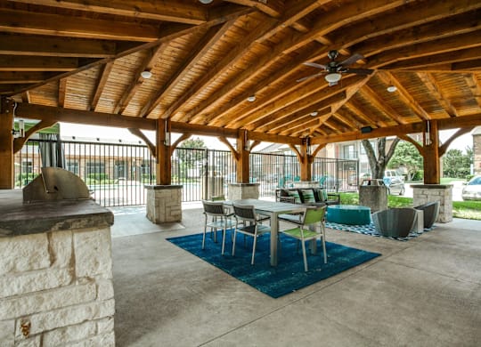 A wooden covered patio with a table and chairs.