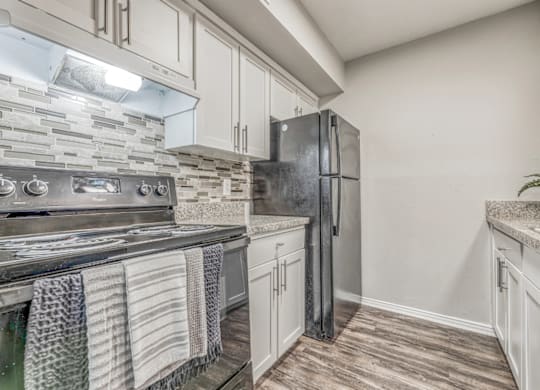 Updated kitchen with white cabinetry and backsplash at Northwood Heights Apartments, Texas, 75248