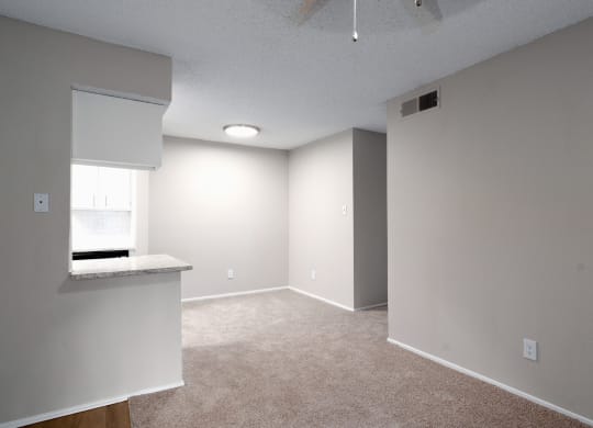 an empty room with a kitchen and a window