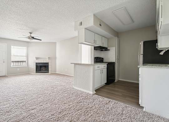 A living room with a fireplace and a ceiling fan. at Anson at North Hills, North Carolina
