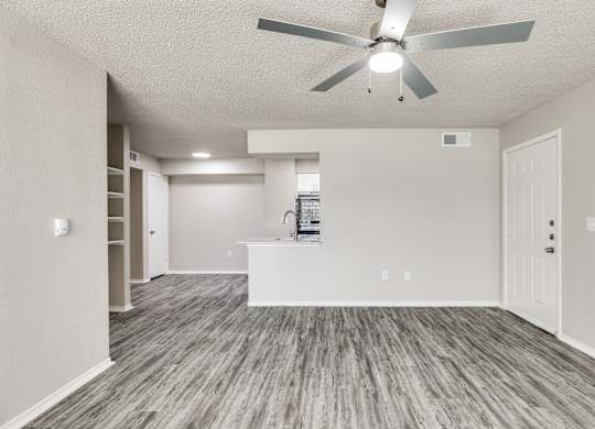A room with a ceiling fan and a white counter.