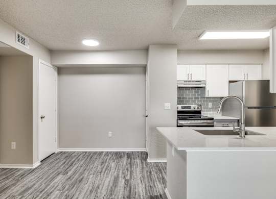 A kitchen with a sink and a refrigerator.
