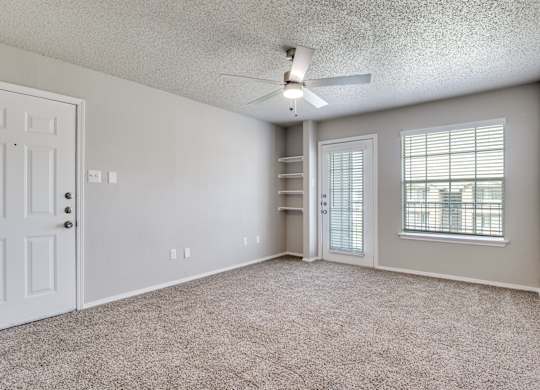 A room with a ceiling fan and a window with blinds.