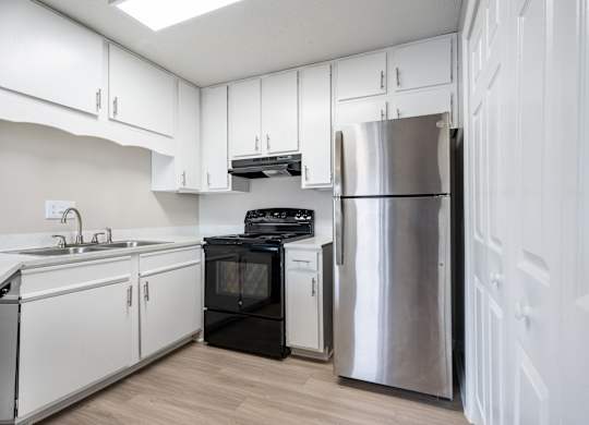 A kitchen with white cabinets and a black oven.
