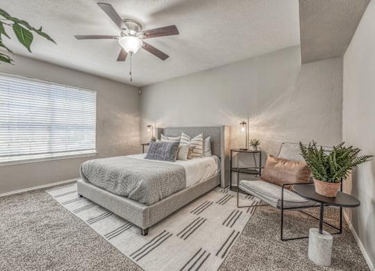 Cozy bedroom with neutral decor and ceiling fan at Northwood Heights Apartments, Dallas, 75248