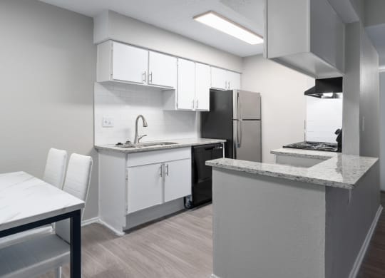 a kitchen and dining room with white cabinets and a stainless steel refrigerator