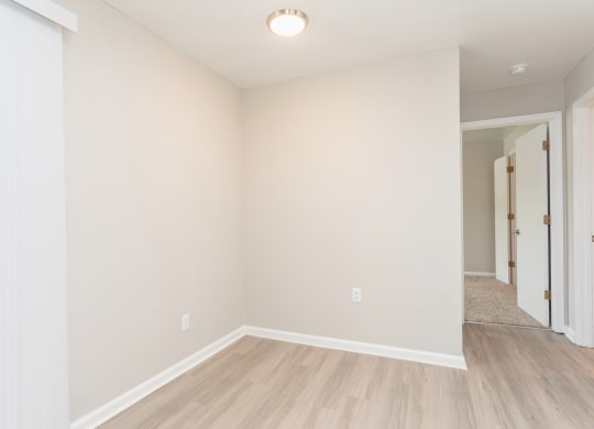 an empty living room with white walls and wood flooring