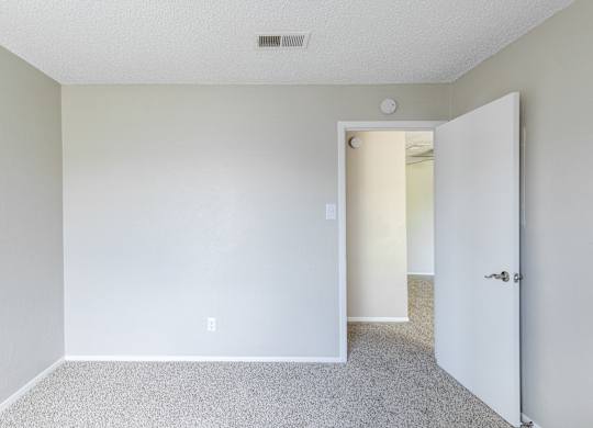 A room with a carpeted floor and a white door. at Leander, Benbrook, 76109