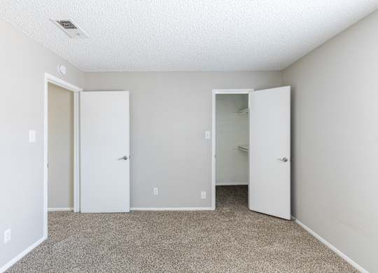 A room with three white doors and carpeted floor. at Leander, Benbrook