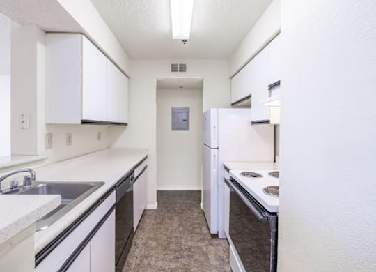 A kitchen with white cabinets and appliances.