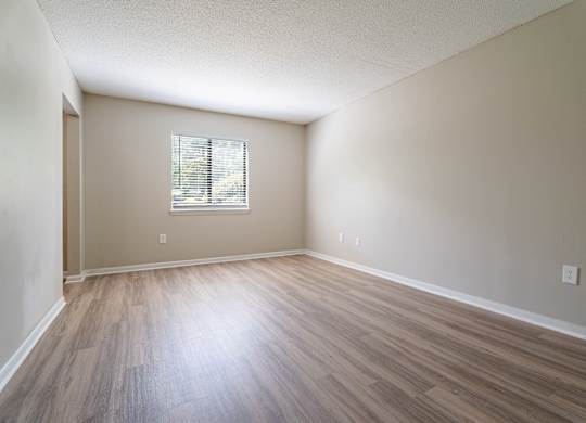 Empty room with wooden flooring and a window. at Rosen at North Hills, Raleigh, NC, 27609