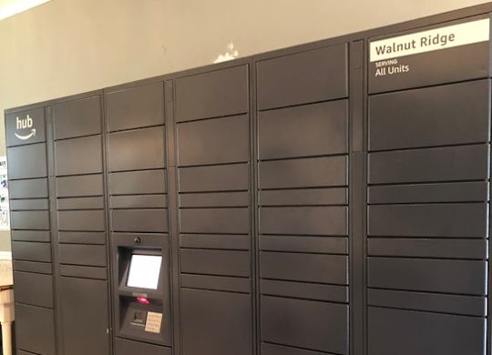 A wall of lockers with a sign that says Walnut Ridge Apartments.