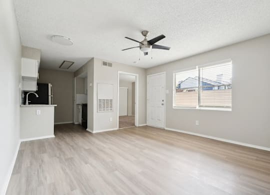 A spacious room with a ceiling fan and light fixture.