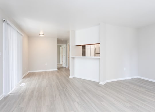 an empty living room with white walls and wood flooring