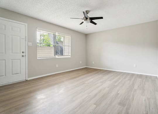 A room with a ceiling fan and a door.